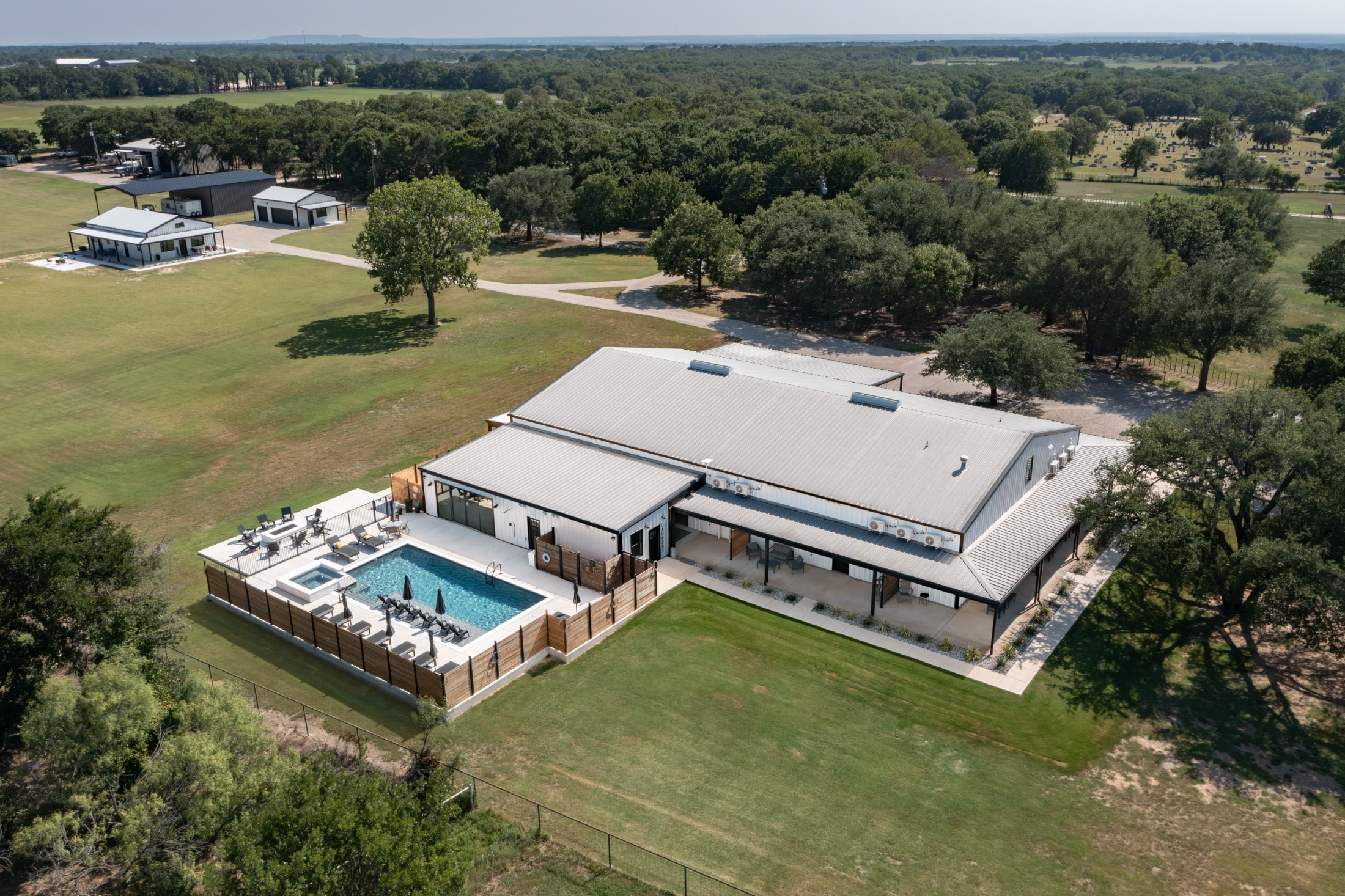 Aerial of the whole property — buildings, pool and drive in one frame