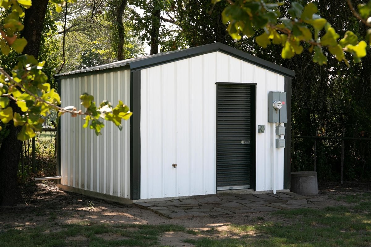Well house — enclosed metal building with roll-up door, electrical service and septic access