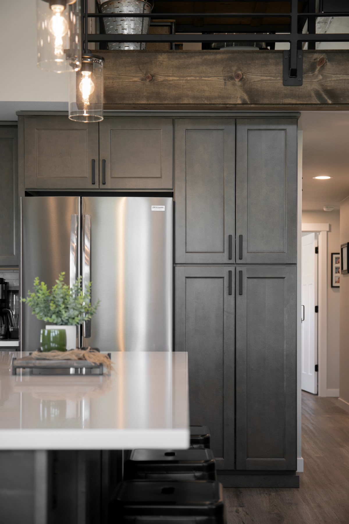 Mini barndominium kitchen — full-size refrigerator and floor-to-ceiling pantry storage
