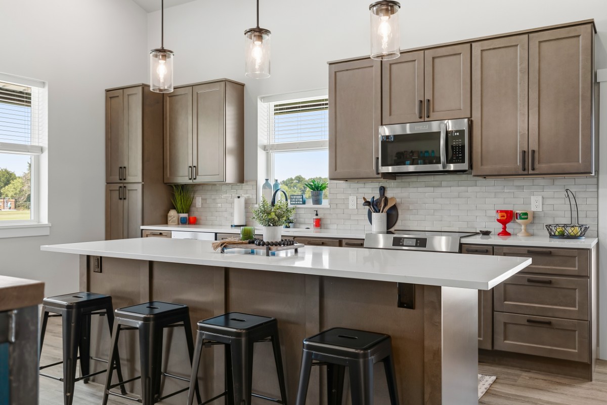 Mini barndominium kitchen — quartz island with seating, subway backsplash, stainless appliances