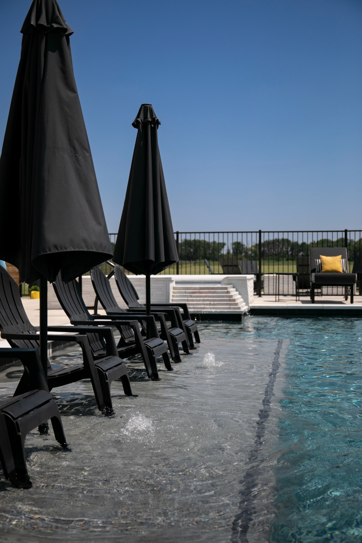 Tanning ledge with in-water chairs, bubblers and umbrellas